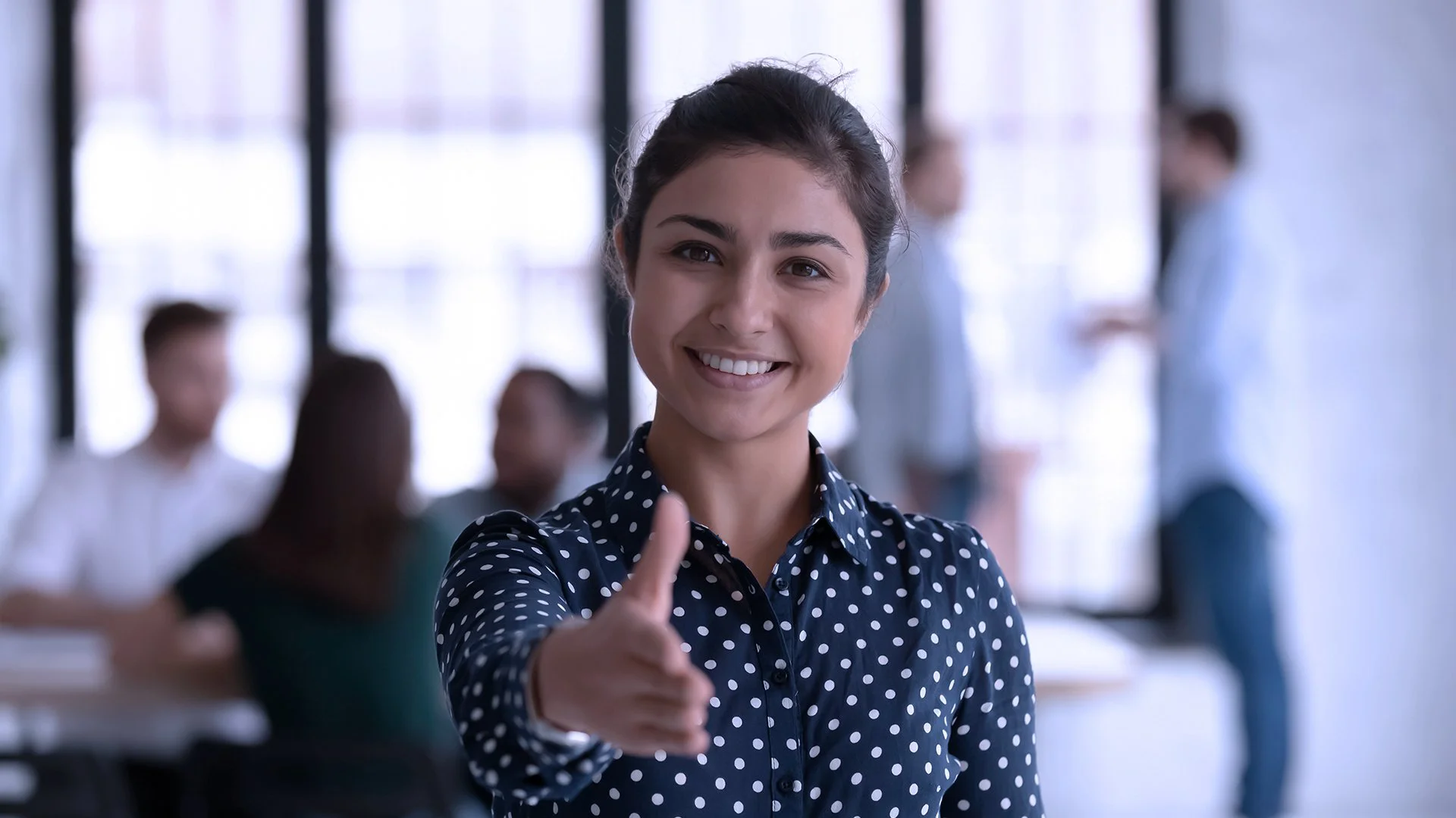 Pessoa estende a mão para cumprimento em ambiente corporativo, simbolizando conexão humana nas campanhas B2B, B2C e H2H