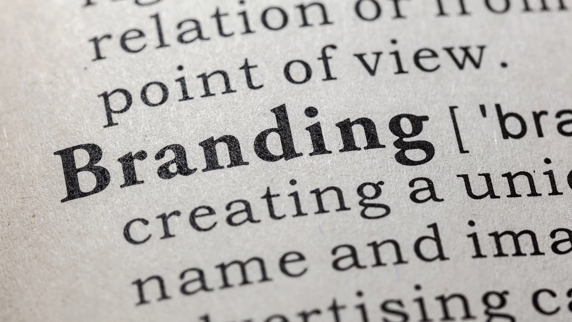 Close de página de dicionário com destaque para a palavra Branding e início de sua definição.